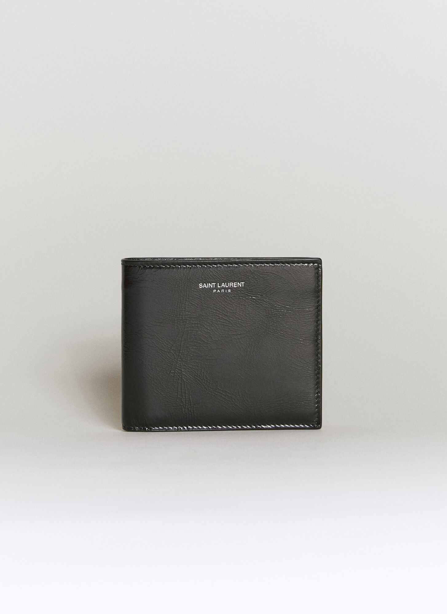 Shop Saint Laurent Logo Embossed Bi-fold Wallet In Black